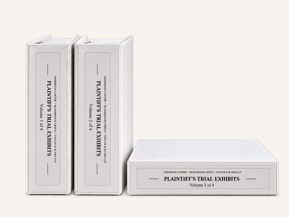 Three white trial exhibit binders labeled Plaintiff’s Trial Exhibits